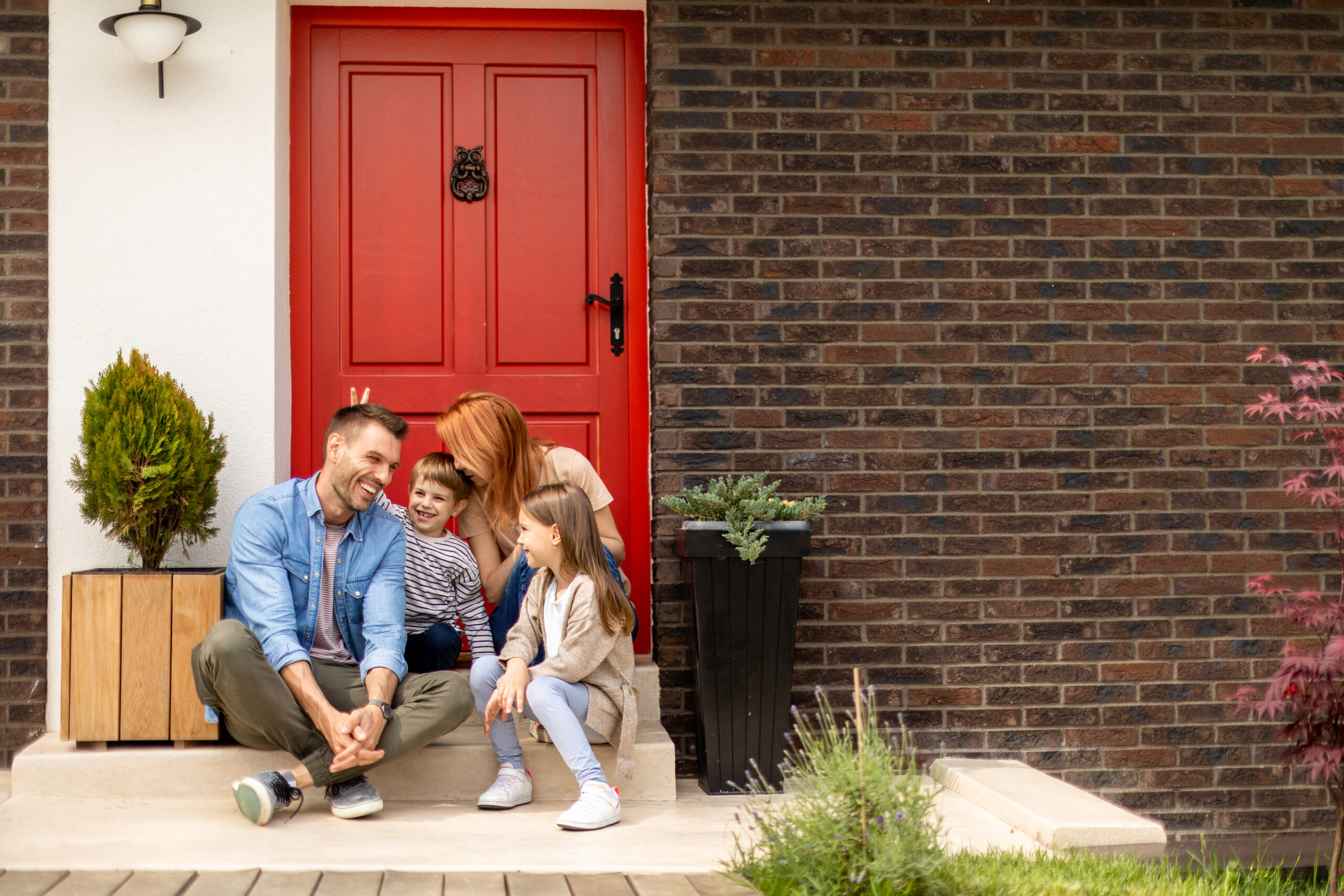 a family sitting on the steps of a house