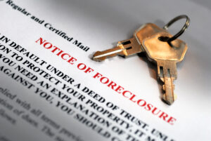 Close up of a foreclosure notice and two keys laying on top of it.